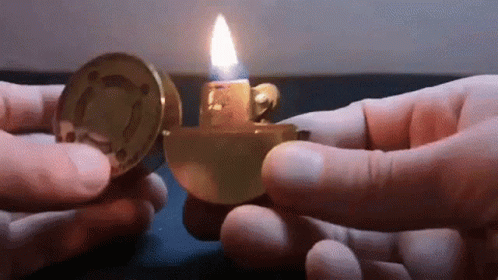 two hands holding up a small lighter in their right hand