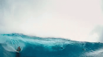 a man on top of a giant wave surfing