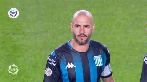 a man in a striped shirt holding a soccer ball