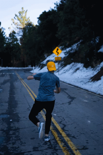 a man is running on the road with snow on his feet