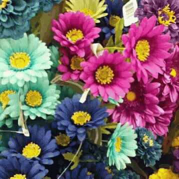 an arrangement of flowers with small blue flowers in the center
