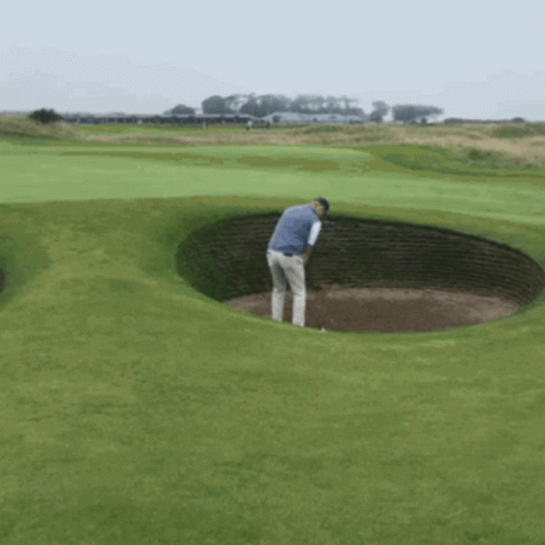a man is taking a picture from a hole on golf