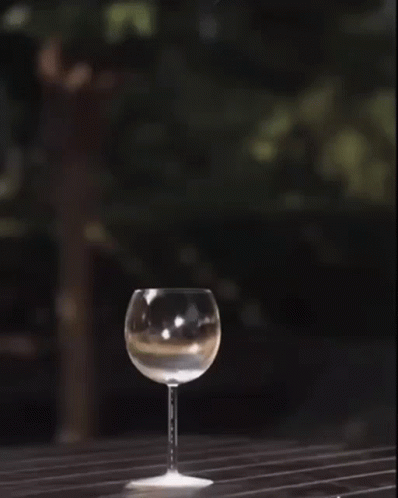 a glass sitting on top of a table on top of a wooden floor