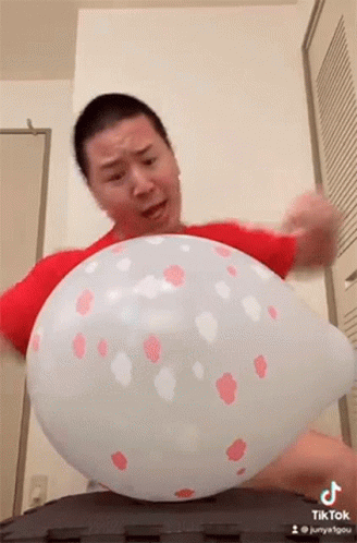 a man that is holding some balloons