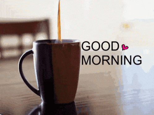 a cup sits on the table that is on a table with a good morning message in the background