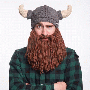 a man with long blue hair and beard in green shirt wearing a viking hat