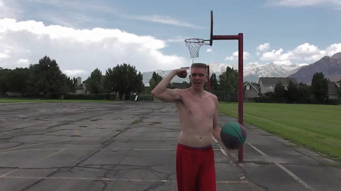 a man holding a basketball next to a net