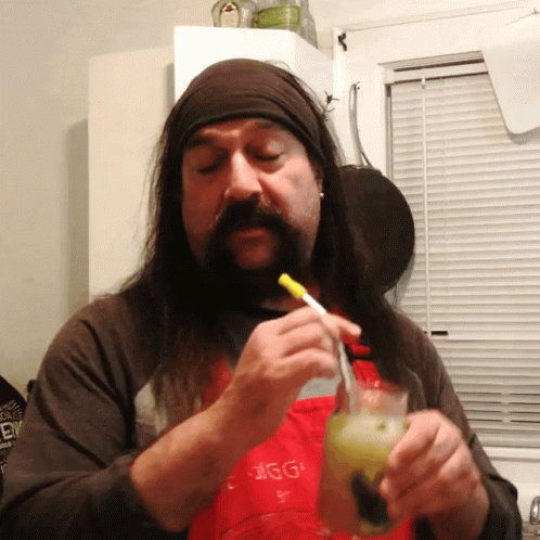a bearded man has a glass in his hand