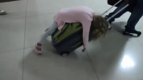 an old woman pulls a luggage bag down the floor