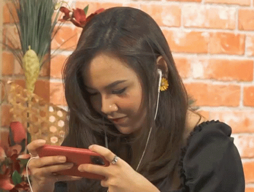 a woman with long hair and a ponytail looking at her cell phone