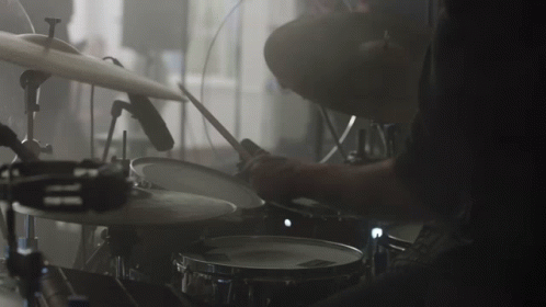 drummer in a dark po playing a drum set