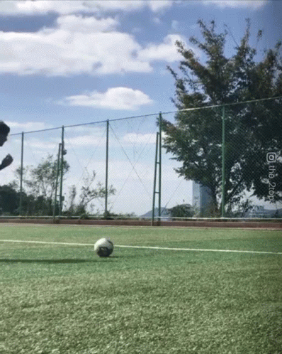 a man running to kick a soccer ball on a tennis court