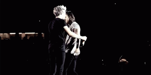 a couple standing together on stage hugging
