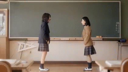 there are two girls standing in front of a large chalkboard