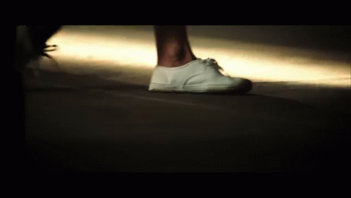 a person with white shoes and dark lights