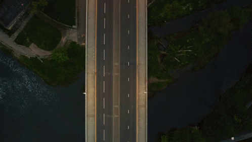 aerial view of a highway running next to a lake at night