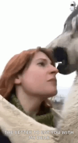 a woman licking an animal's face with a blue nose