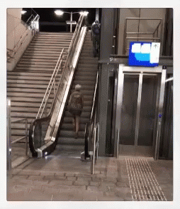 an escalator with two people walking along side it