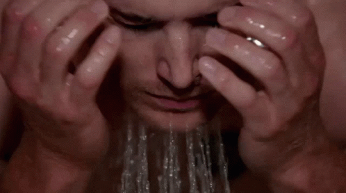 a man with his hands on his head is shown with water splashing from the top of his head