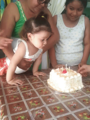 the young children sit at the table with a cake