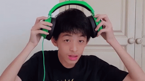 a boy is holding headphones to his ears