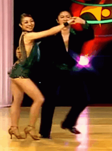 two people dressed in dance clothing on stage