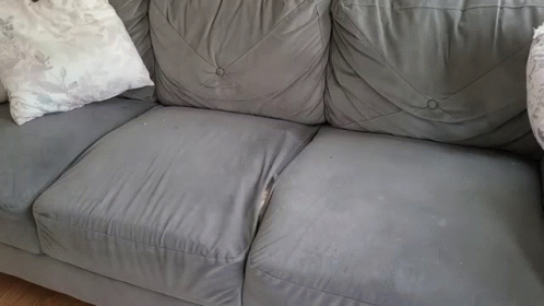 the couch has three white pillows on it