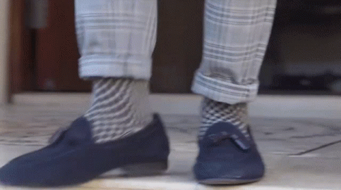 a person is wearing plaid pants and brown shoes