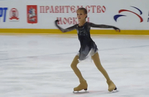 a woman wearing ice skating clothes riding on an ice rink