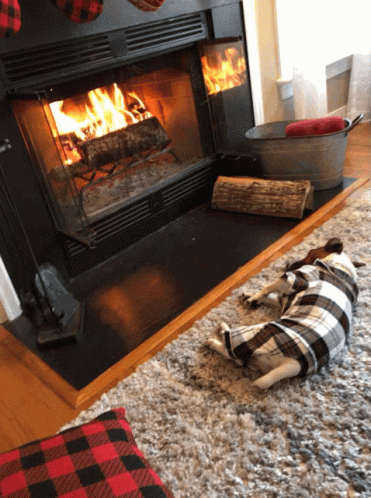 two plaid pillows and a plaid towel lay by the fireplace