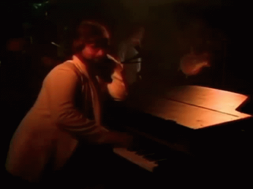 a man is playing the piano in the dark