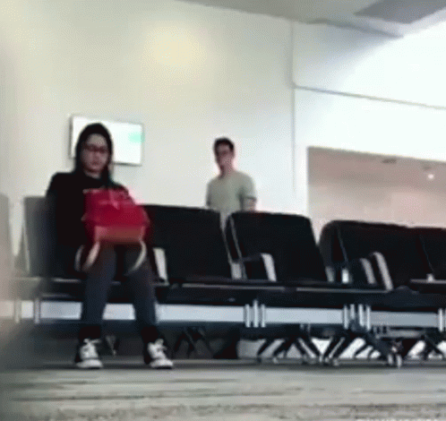 people standing around in an airport waiting for their next flight