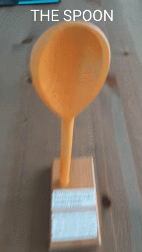 a broom and a blue cup on top of a block