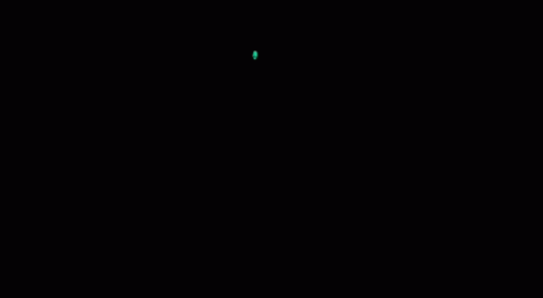 a ball flying in the dark with a red dot on it