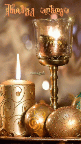 a candle is sitting on a blue table next to other christmas ornaments