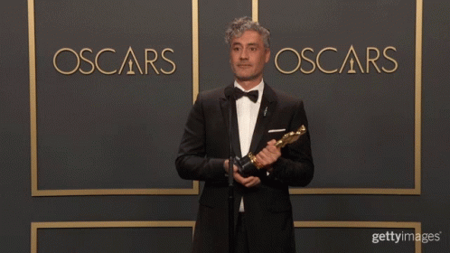 this is a man standing next to an oscar sign