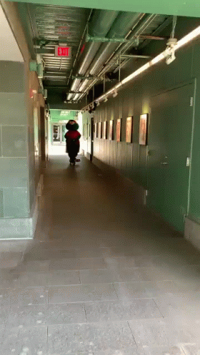 a guy walks down a long hallway lined with lockers