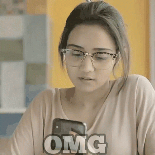 a woman with glasses looks at her cellphone