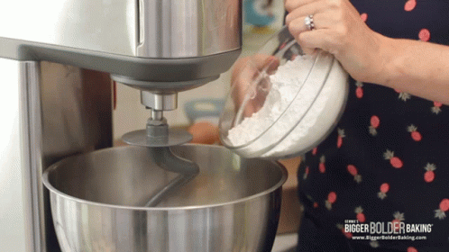 the woman is using her mixer to make a meal