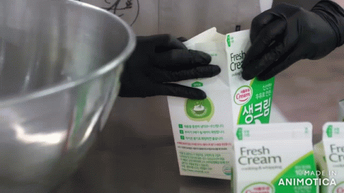 hands in black gloves holding a packet of antibiotictic cream