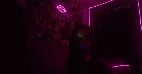 a woman is illuminated by purple neon lights