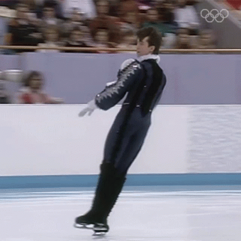 a man in an olympic outfit on the ice skating