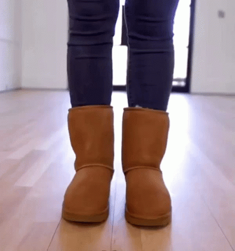 a person wearing blue boots standing on a hard wood floor