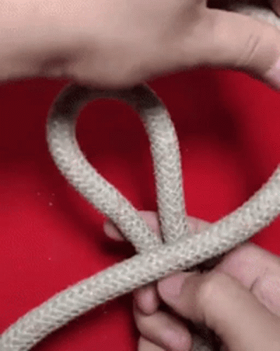 a hand holding up a white rope with its end
