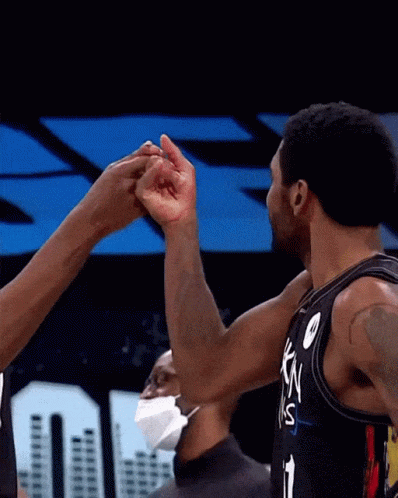 two basketball players in blue are holding up their hands