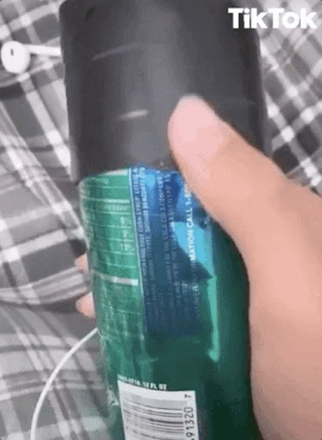 a person wearing a purple shirt is holding a green bottle