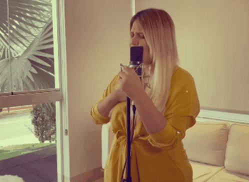the blonde woman is holding a recorder and recording