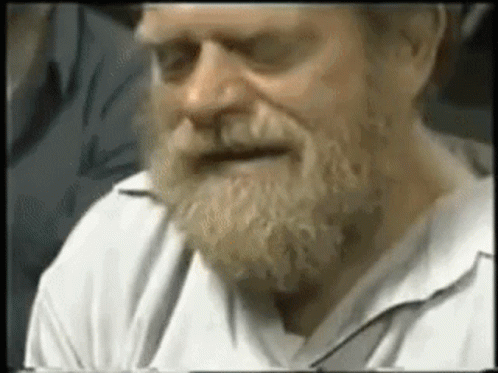 an old man wearing a white shirt and beard