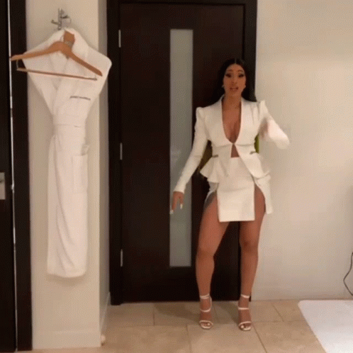 the woman is dressed in white clothes next to a closet