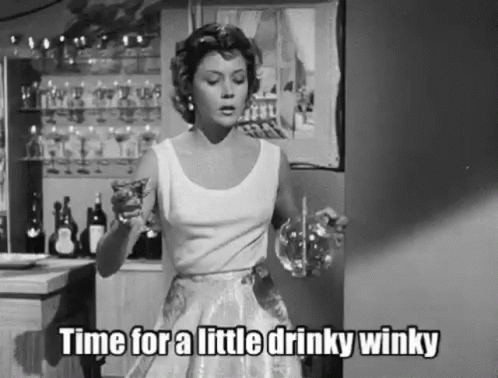 a woman in a short dress is drinking wine